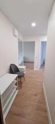 an empty room with a chair and a couch in it at Sonata apartment in Panevėžys