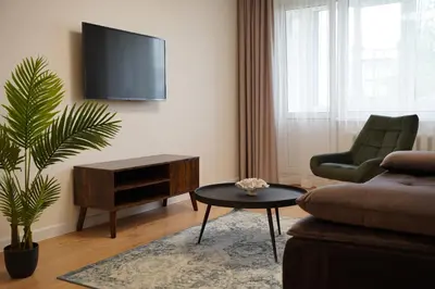 a living room with a tv and a couch and a table at Sonata apartment in Panevėžys