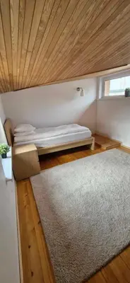 a small bedroom with a bed and a rug at Laurentroom Townhouse in Ukmergė