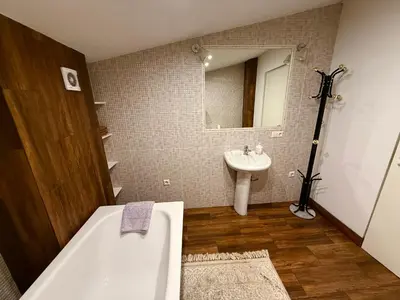 a bathroom with a bath tub and a sink at CENTRO House in Alytus