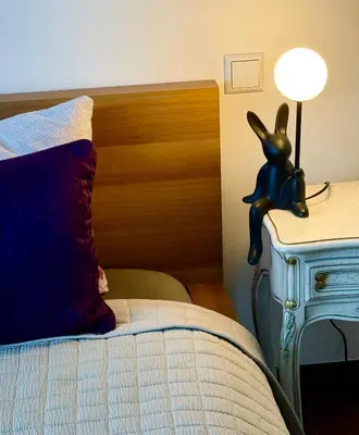 a bedroom with a bed with a lamp on a table at CENTRO House in Alytus