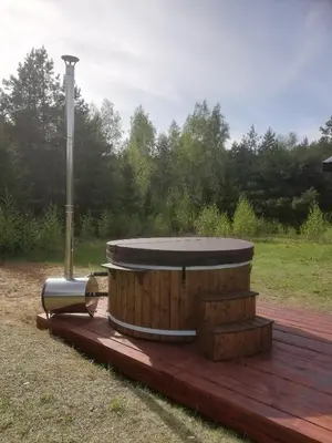 a hot tub sitting on a wooden deck at Piglet house in Alytus