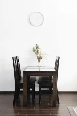 a dining room table with two chairs and a vase with flowers at 1 House Between two lakes in Vilnius