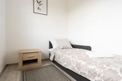 a small bedroom with a bed and a night stand at 1 House Between two lakes in Vilnius