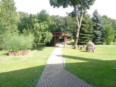 a brick walkway in a park with a gazebo at Sodyba Skardupiai in Vidgiriai