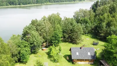 an aerial view of a house on the shore of a lake at Sodyba “Rita” in Mėčiūnai
