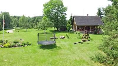 a yard with a playground in front of a house at Sodyba “Rita” in Mėčiūnai