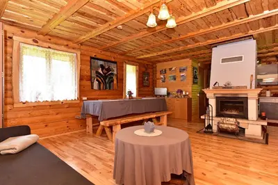 a living room with a table and a fireplace at Sodyba “Rita” in Mėčiūnai