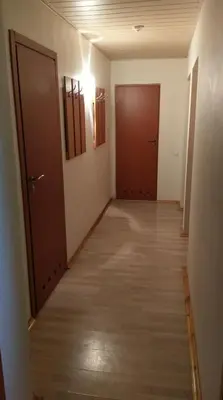 an empty hallway with two doors and wooden floors at Berzu aleja in Birštonas