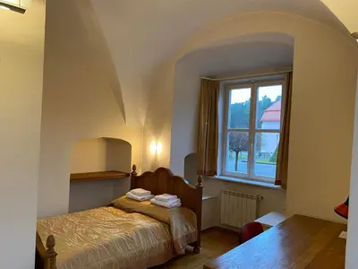 a bedroom with a bed and a window at Liškiavos vienuolyno ansamblis in Liškiava