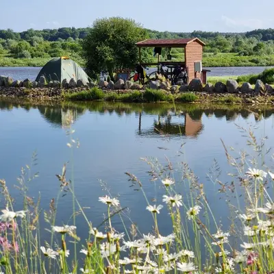 a tent on an island in the middle of a lake at Camp Genys in Jurbarkas