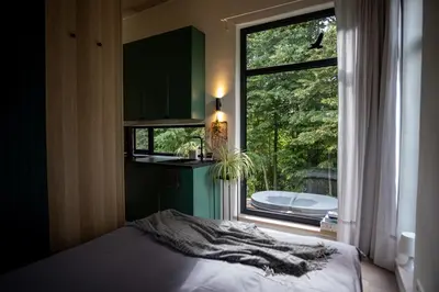 a bedroom with a bed and a large window at Birštonas Tiny Hemp House in Birštonas