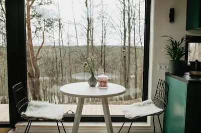 a table and two chairs in front of a window at Birštonas Tiny Hemp House in Birštonas