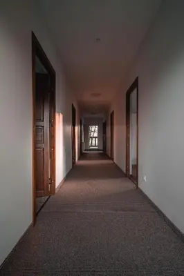 an empty hallway of an empty building with doors at Vėjo Malūnų sodyba - vila in Paserninkai