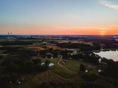 an aerial view of a park with the sunset in the background at Vėjo Malūnų sodyba - vila in Paserninkai