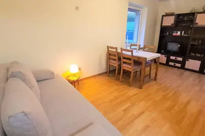 a living room with a couch and a table at Butas Ignalinos centre poilsiui ir darbostogoms in Ignalina
