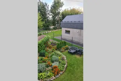 an image of a garden with a building at Butas Ignalinos centre poilsiui ir darbostogoms in Ignalina