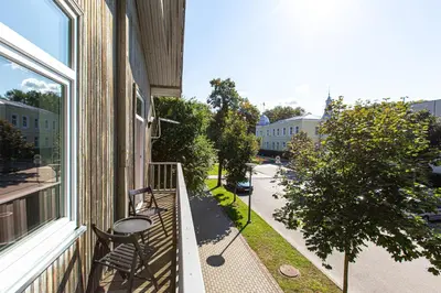 a balcony of a building with a bench and a street at à la fontaine in Druskininkai