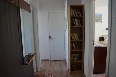 a hallway with a door and a book shelf at Mildos butas in Birštonas