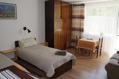 a bedroom with a bed and a table and a chair at Mildos butas in Birštonas