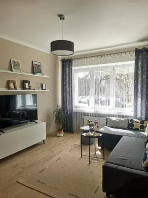 a living room with a couch and a tv at The good stay in Šiauliai