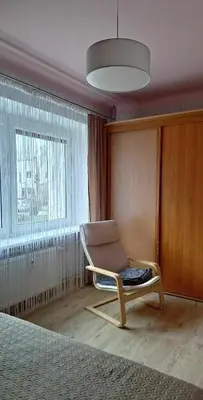 a bedroom with a chair and a large window at The good stay in Šiauliai