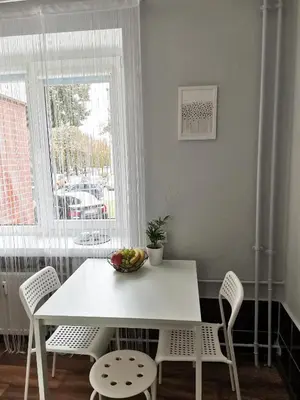 a white table and chairs with a bowl of fruit on it at The good stay in Šiauliai
