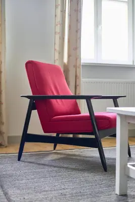 a red chair sitting in a room with a table at Lovely, Best View Apartment, Vilnius City Centre in Vilnius