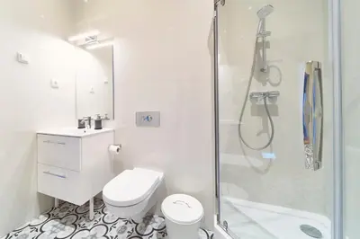 a white bathroom with a shower and a toilet at Lovely, Best View Apartment, Vilnius City Centre in Vilnius