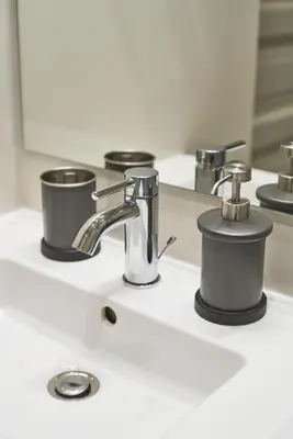 a bathroom sink with two cups and a faucet at Lovely, Best View Apartment, Vilnius City Centre in Vilnius