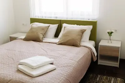a bedroom with a bed with two white towels on it at 3 Apartment Between two lakes in Vilnius