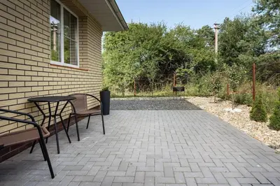 a patio with two chairs and a table next to a house at 3 Apartment Between two lakes in Vilnius