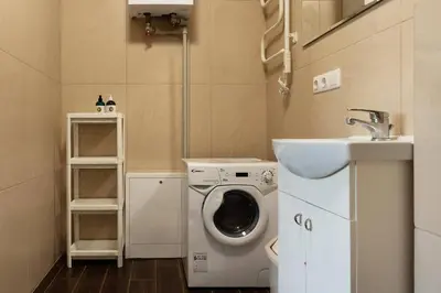 a small bathroom with a washing machine and a sink at 3 Apartment Between two lakes in Vilnius