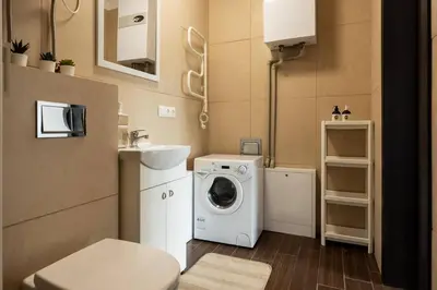 a bathroom with a washing machine and a sink at 4 Apartment Between two lakes in Vilnius