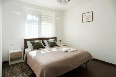 a bedroom with a large bed with a window at 4 Apartment Between two lakes in Vilnius
