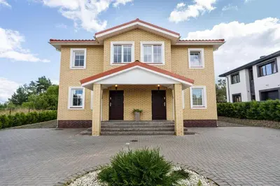 a yellow house with a brick driveway at 4 Apartment Between two lakes in Vilnius
