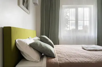 a bedroom with a bed with pillows and a window at 2 House Between two lakes in Vilnius