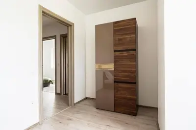 a room with a closet with a large wooden door at 2 House Between two lakes in Vilnius