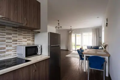 a kitchen with a refrigerator and a table with chairs at 2 House Between two lakes in Vilnius