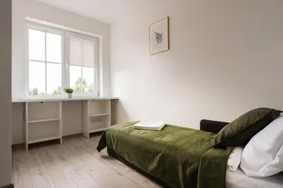 a white bedroom with a bed and a window at 2 House Between two lakes in Vilnius