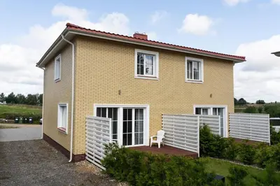 a yellow house with a chair in front of it at 2 House Between two lakes in Vilnius