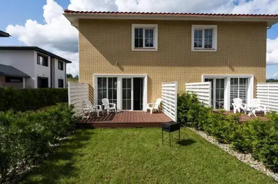 a house with a wooden deck and chairs on it at 2 House Between two lakes in Vilnius