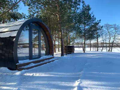 a building with a window in the snow at Kedras Glamping - Pod tipo nameliai in Prapuntai