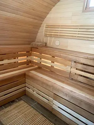 a sauna with wooden benches in a room at Kedras Glamping - Pod tipo nameliai in Prapuntai