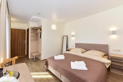 a bedroom with a large bed with towels on it at Panorama in Trakai