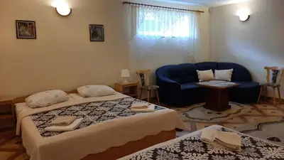 a hotel room with two beds and a blue couch at Panorama in Trakai