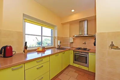 a kitchen with yellow cabinets and a window at Panorama in Trakai