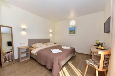 a bedroom with a bed and a table and a mirror at Panorama in Trakai