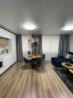 a living room with a table and a blue couch at Forest Studio in Druskininkai