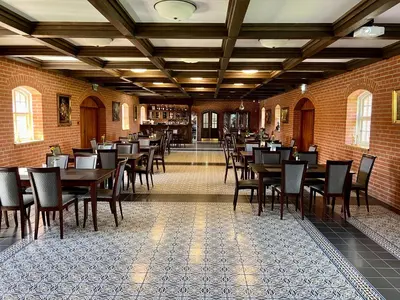 a dining room with tables and chairs in a building at Pakėvio dvaras - Pakevis manor in Kelmė